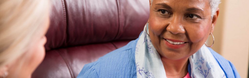 Smiling woman engaging in a conversation about preventing hospital readmission.