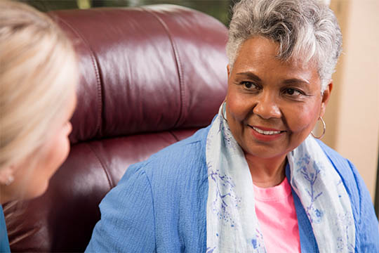 Smiling woman engaging in a conversation, reflecting AdvisaCare’s focus on attentive and personalized patient care