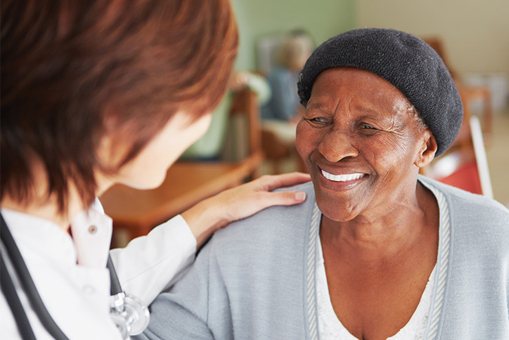 Advisacare healthcare professional comforting a smiling patient, emphasizing personalized care and independence.