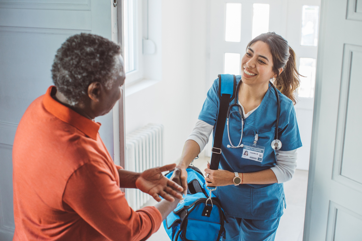 Home health nurse providing care to a patient at home